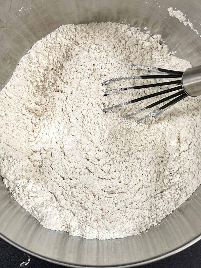 Dry ingredients for sweet potato coffee cake whisked together in a metal bowl.