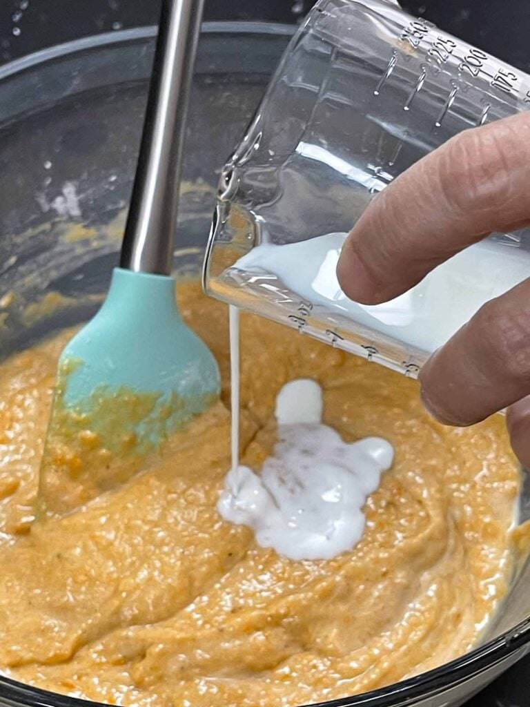 Buttermilk being added to the sweet potato coffee cake batter.