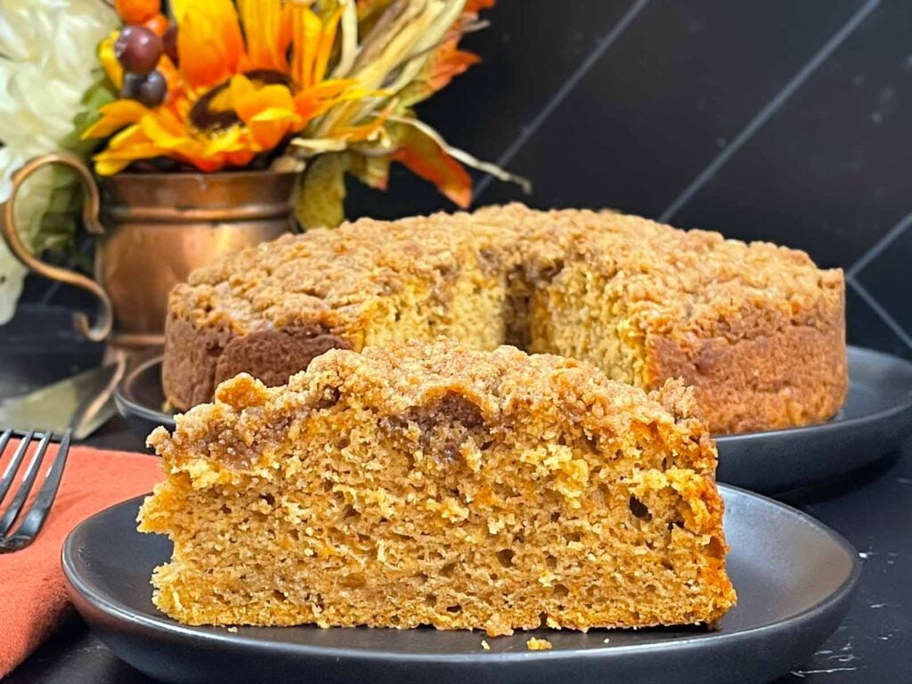 A slice of sweet potato coffee cake on a dark plate.