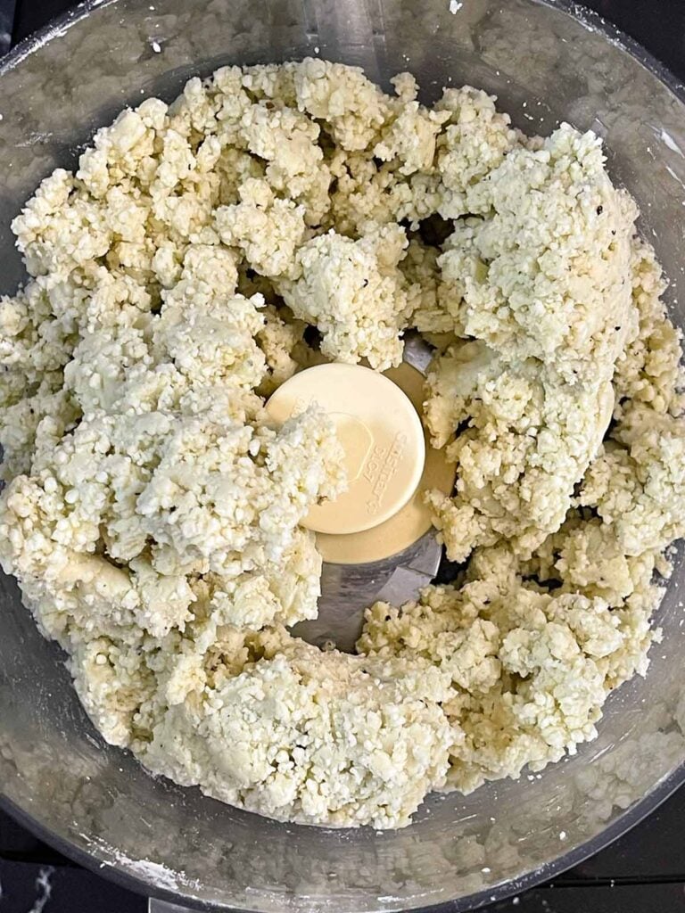 Blue cheese wafer dough mixed in the bowl of a food processor.