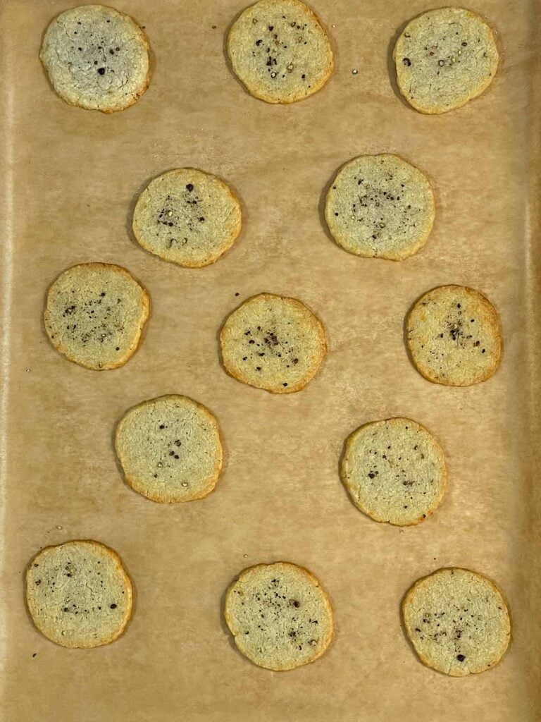 Baked blue cheese wafers on a parchment paper lined baking sheet.