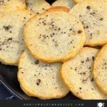 Blue cheese wafers stacked on a dark plate.