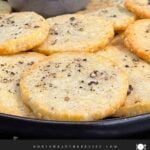 Blue cheese wafers stacked on a dark plate.