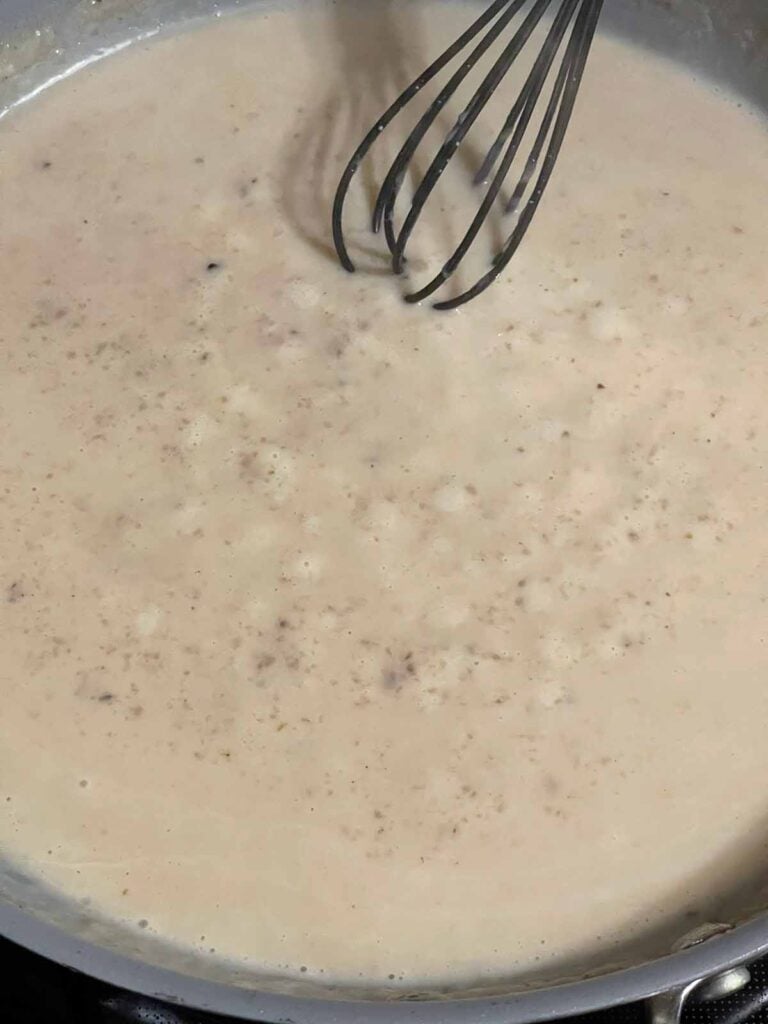 Cream sauce cooking in a skillet.