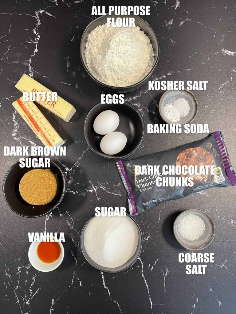 Crispy and chewy chocolate chip cookies recipe ingredients on a dark surface.