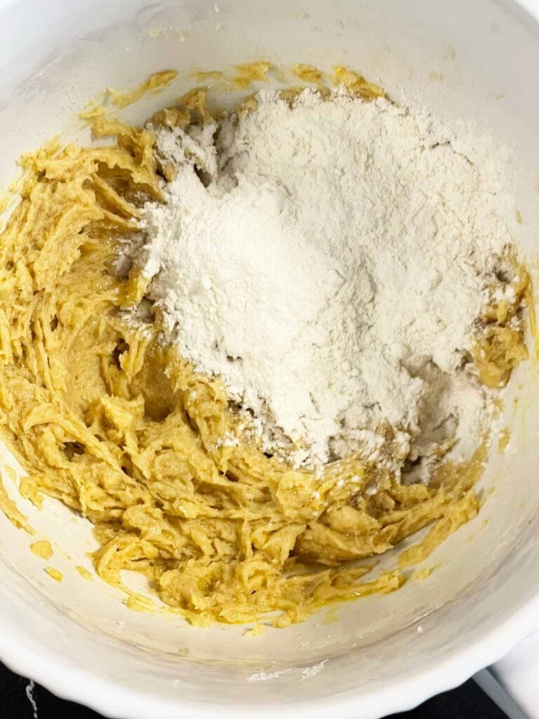 Dry ingredients being added to the wet ingredients for the chocolate chip cookies recipe.