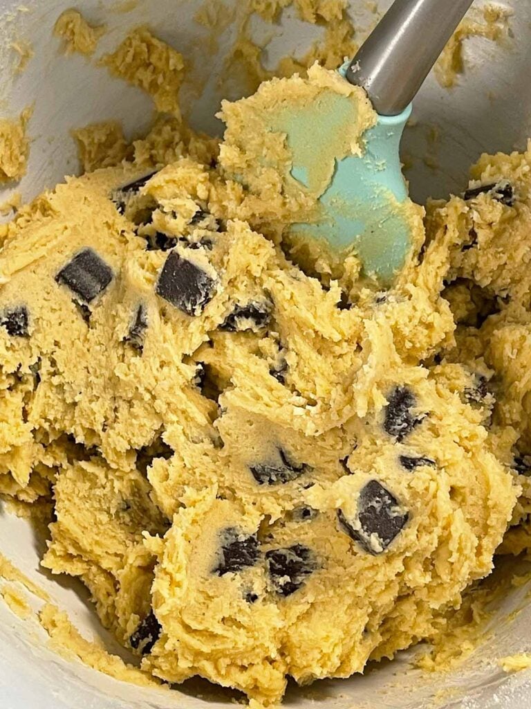 Mixed chocolate chip cookie dough in a light bowl.
