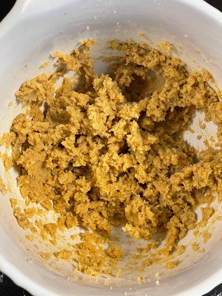 Butter and sugars creamed together in a light bowl for chocolate chip cookies recipe.