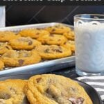 Crispy and chewy chocolate chip cookies on dark plate.