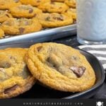 Crispy and chewy chocolate chip cookies on dark plate.