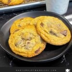 Crispy and chewy chocolate chip cookies on dark plate.