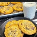 Crispy and chewy chocolate chip cookies on dark plate.