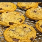 Crispy and chewy chocolate chip cookies on wire rack over a baking sheet.