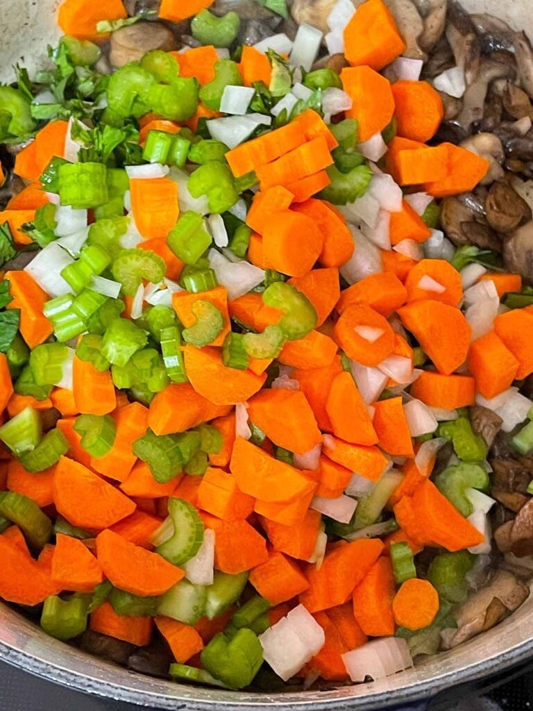 Diced celery, onions, and carrots added to the mushroom in the Dutch oven.