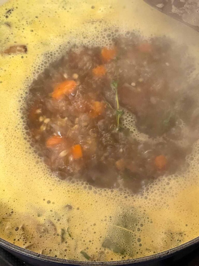 Mushroom barley soup simmering in a Dutch oven.