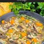 Mushroom barley soup in a dark bowl garnished with minced parsley and fresh thyme.