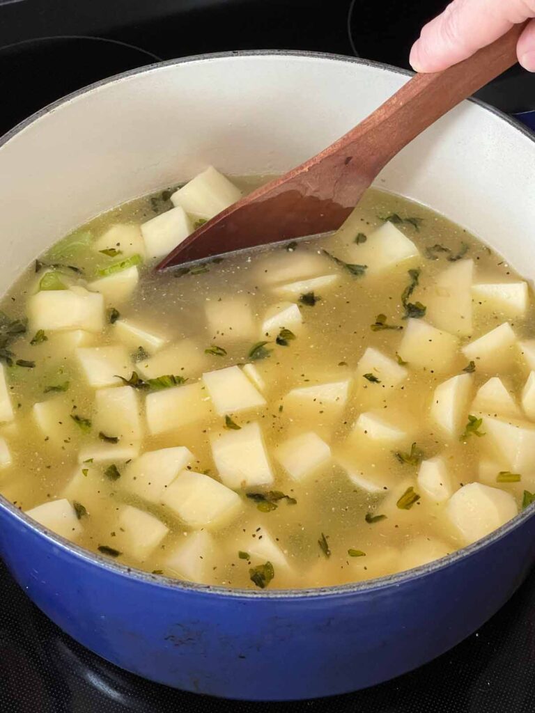 Chicken broth and diced potatoes added to the Dutch oven.