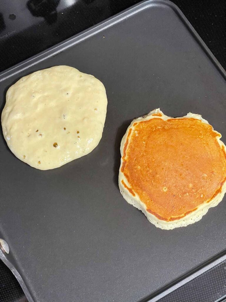 Flipping banana pancakes as they turn golden brown on a griddle.