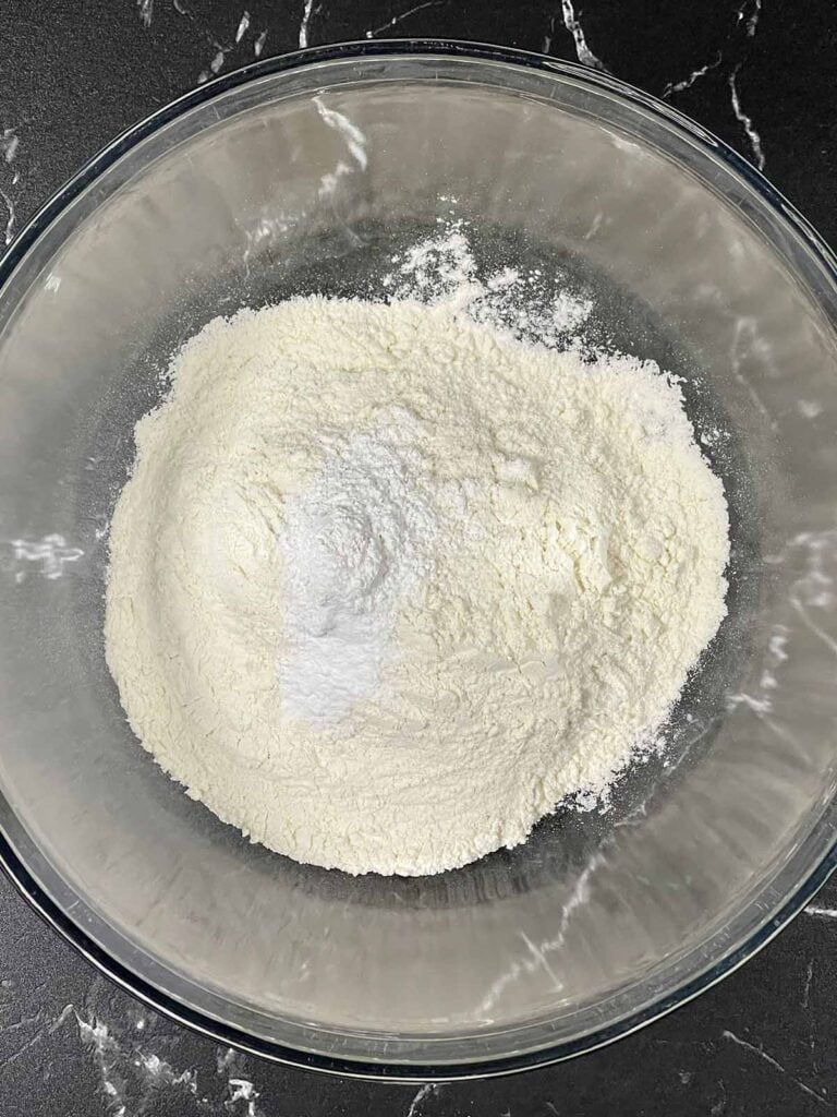 Dry ingredients for biscuits in a glass bowl.