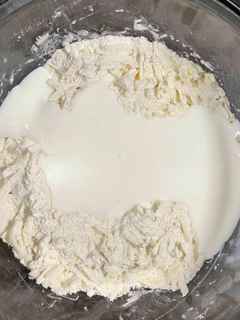 Buttermilk added to other ingredients for biscuits.
