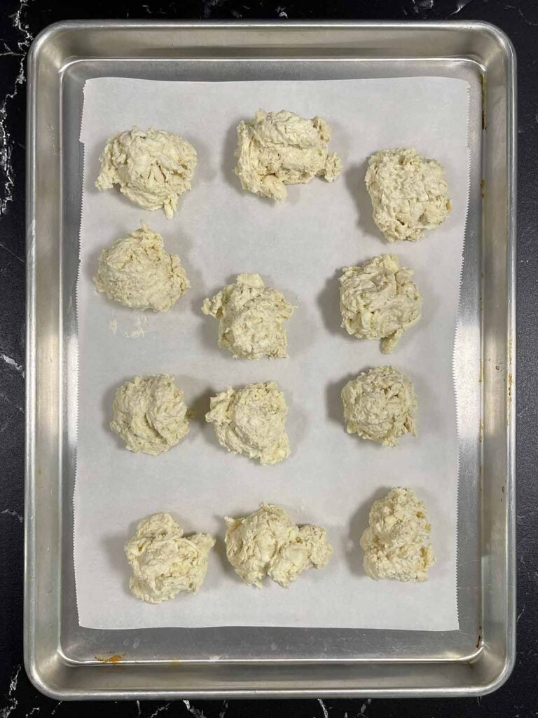 Biscuit dough divided out into 12 drop biscuits.