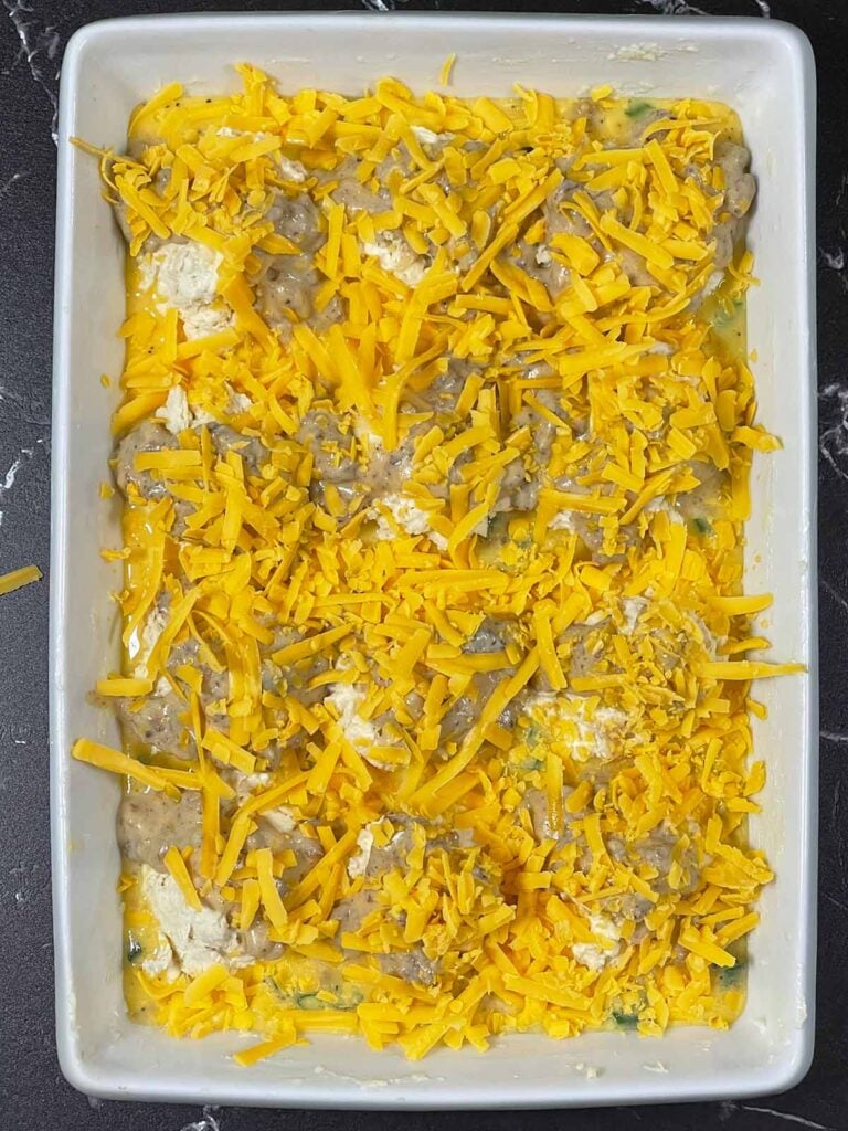 Biscuits and gravy breakfast casserole topped with cheese ready to go into the oven.