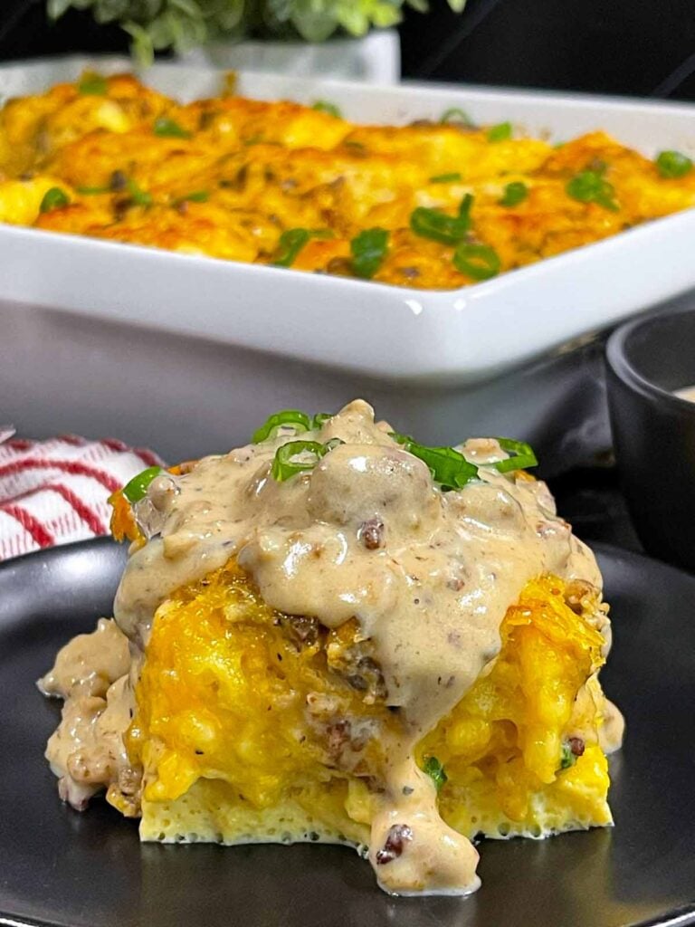 A serving of biscuits and gravy breakfast casserole on a dark plate.