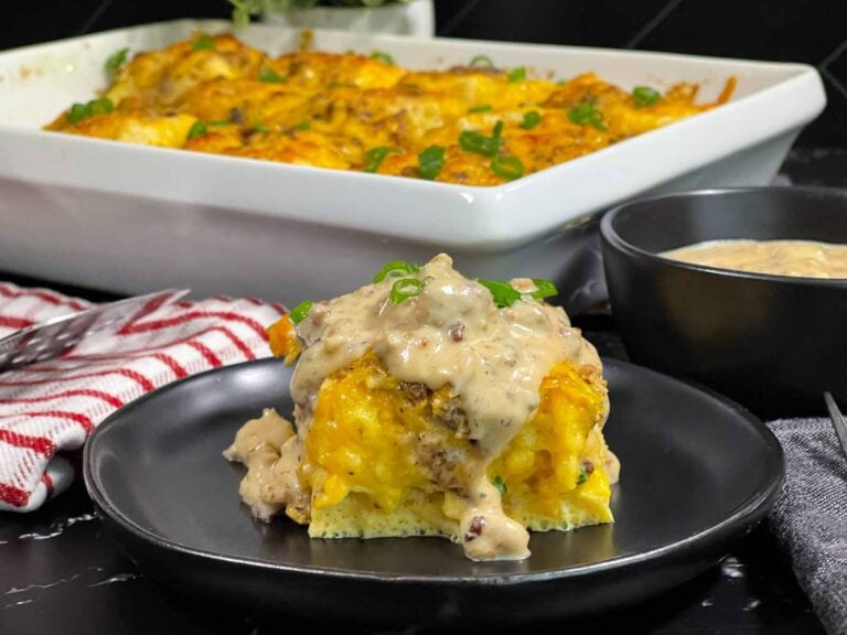 A serving of biscuits and gravy breakfast casserole on a dark plate.