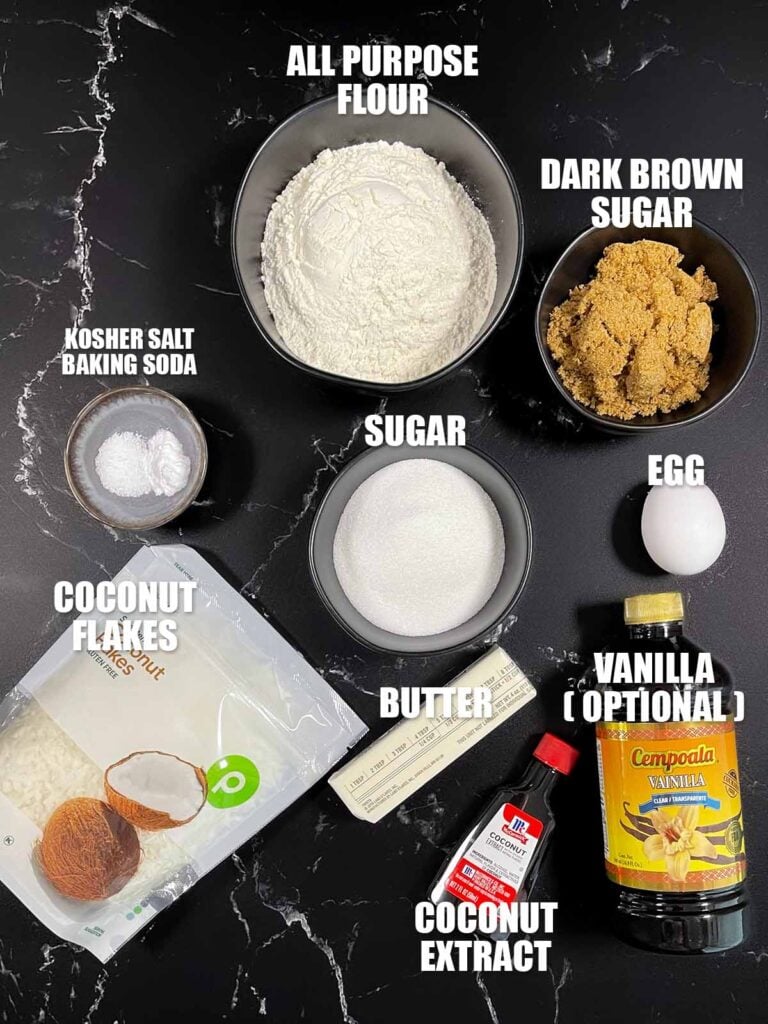 Ingredients for chewy coconut cookies recipe on a dark surface.