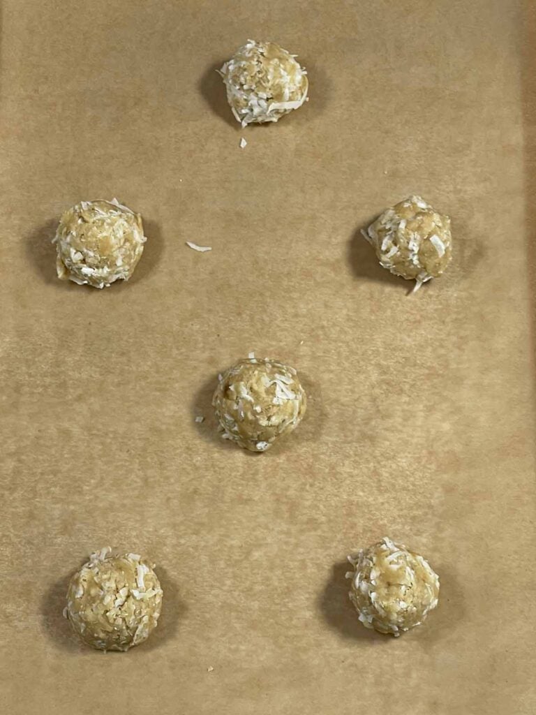 Scooped cookie dough balls placed on baking sheet ready to bake.