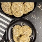 Stack of chewy coconut cookies on a dark plate sprinkled with toasted shredded coconut.