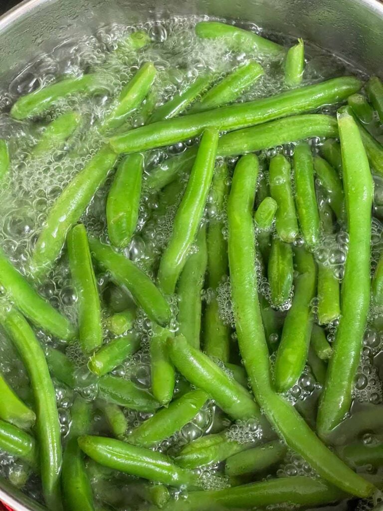 Green beans cooking until crisp tender in boiling water.