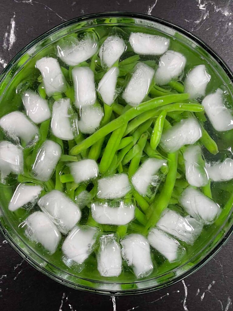 Green beans in ice bath to keep bright green color.