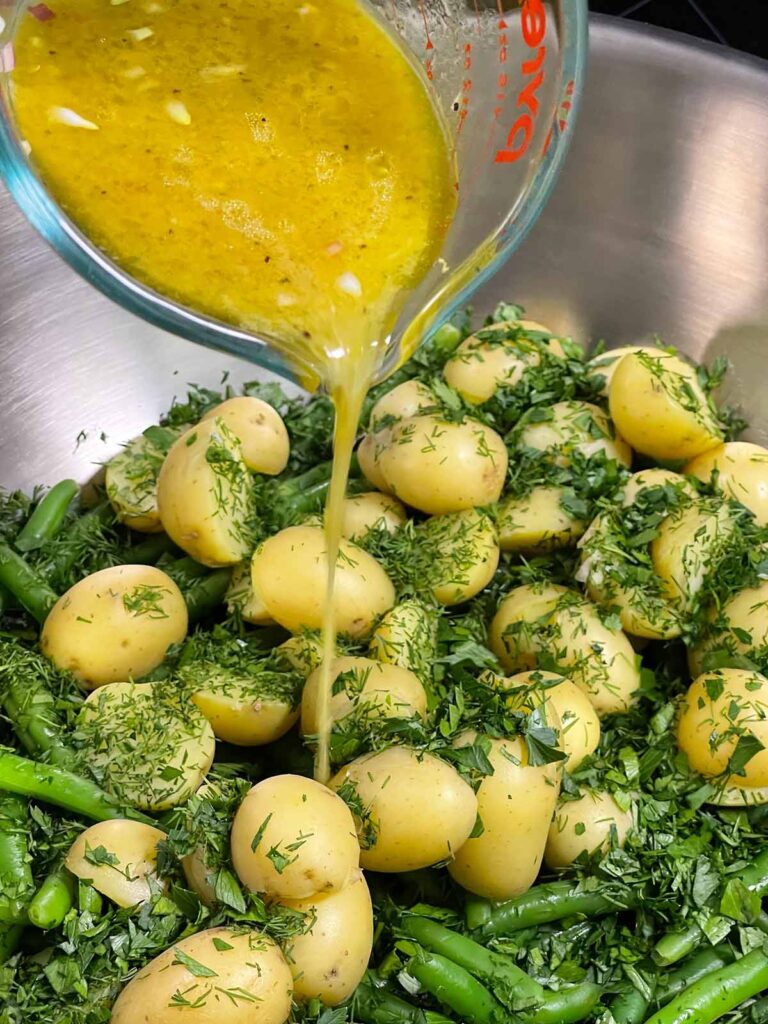 Tossing potatoes and green beans with lemon dill dressing.
