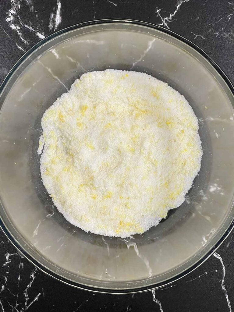 Fresh lemon zest rubbed into sugar to enhance the flavor of lemon crumb muffins.