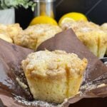 Freshly baked lemon crumb muffins with golden domed tops and crisp streusel topping.