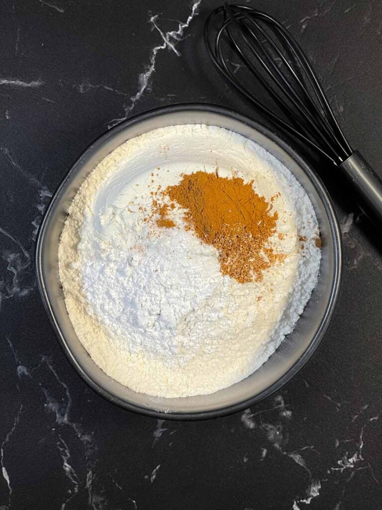 Dry ingredients including flour, sugar, baking powder, and salt in a bowl.