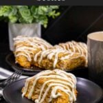 Carrot cake scone on a dark plate garnished with ground nutmeg and cinnamon.