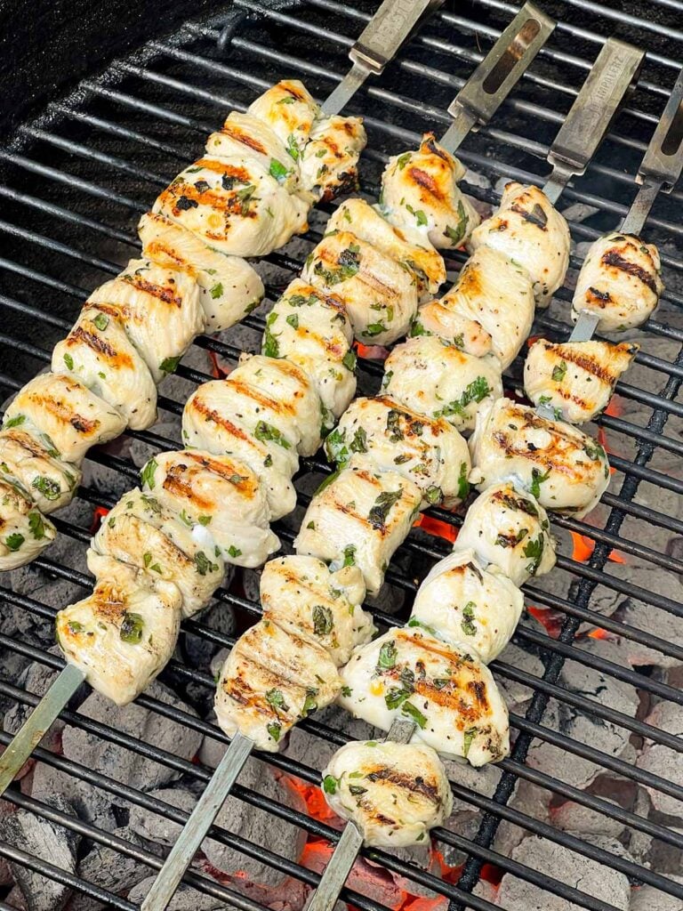 Chicken skewers grilling on a Weber grill.