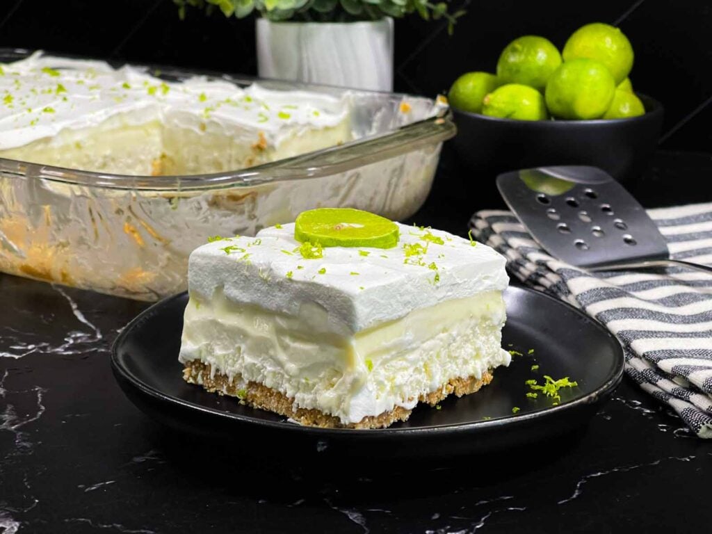 Key lime lush on a round plate garnished with lime zest and a lime slice.