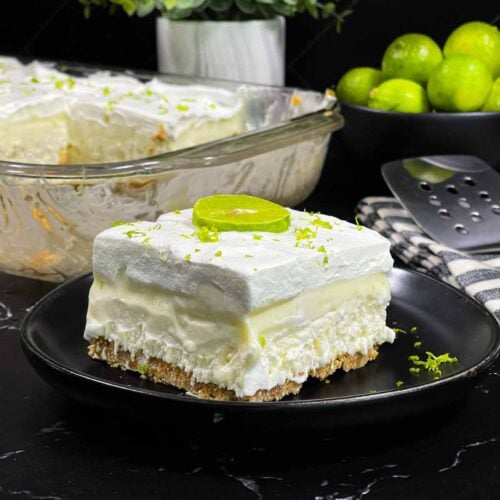 Key lime lush on a round plate garnished with lime zest and a lime slice.