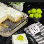 A slice of key lime lush on a round plate garnished with a lime slice and zest.