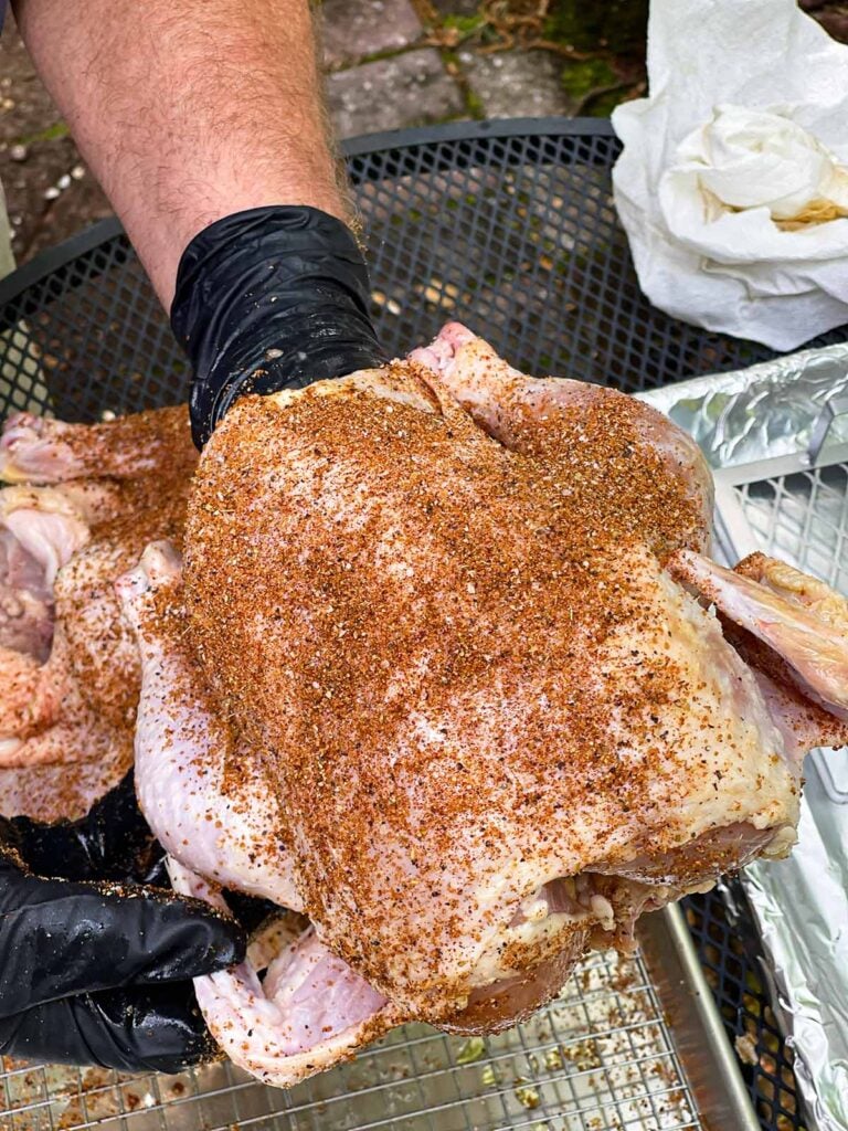 Applying rub to a whole chicken.