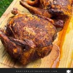 Two smoked chickens on a wooden cutting board.