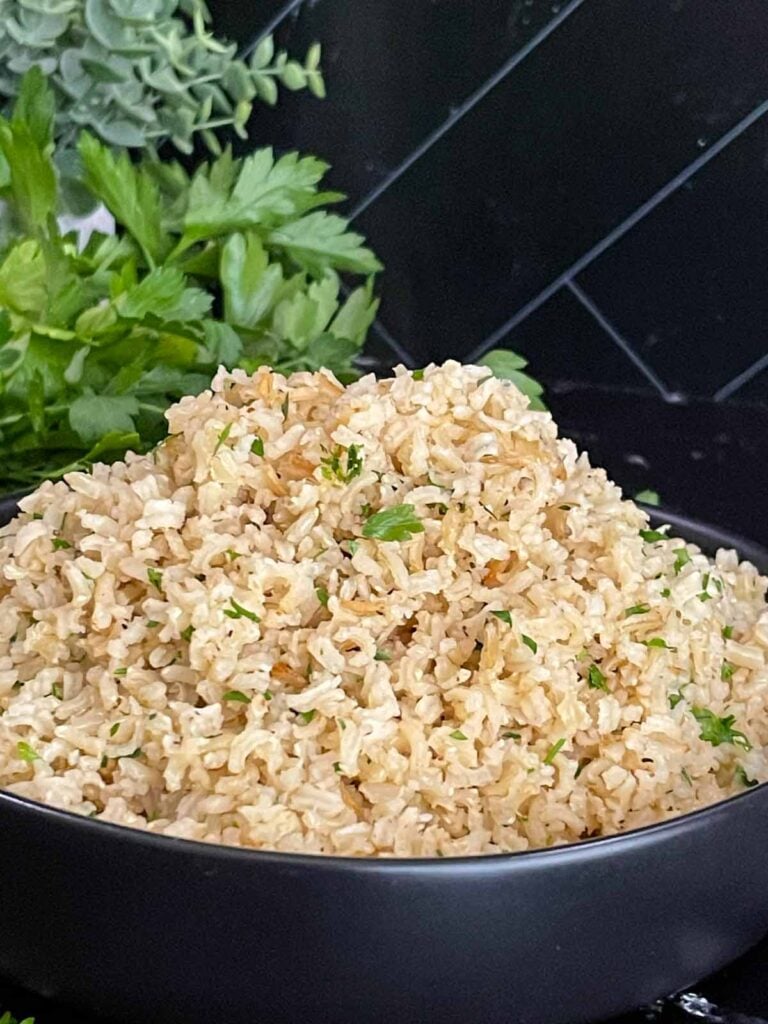 Baked brown rice served in a dark bowl.