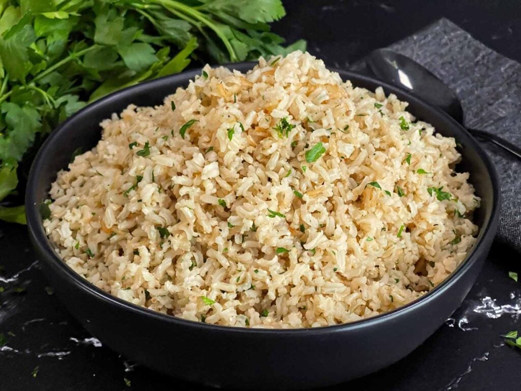 Baked brown rice served in a dark bowl.