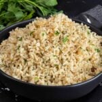 Baked brown rice served in a dark bowl.