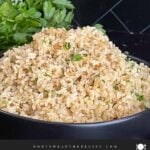 Baked brown rice served in a dark bowl.