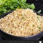 Baked brown rice served in a dark bowl.