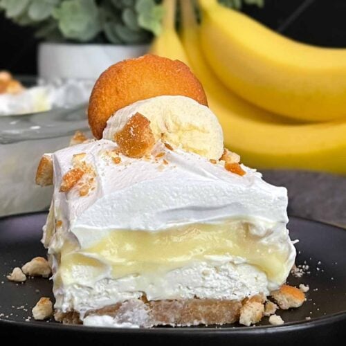 A serving of banana pudding lush on a dark plate.